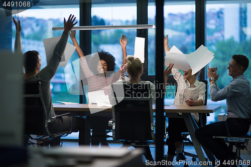 Image of multiethnic Group of young business people throwing documents