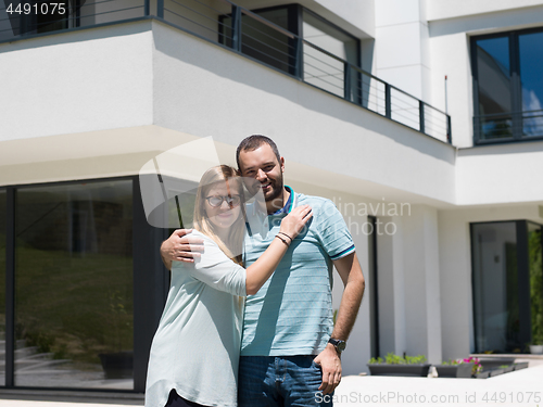 Image of couple hugging in front of  new luxury home