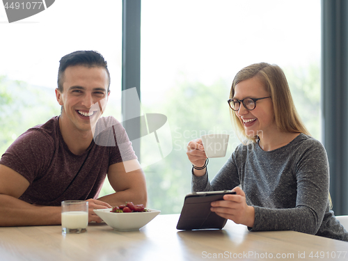 Image of couple enjoying morning coffee and strawberries