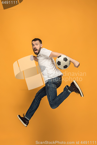 Image of The young man as soccer football player kicking the ball at studio