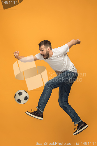 Image of The young man as soccer football player kicking the ball at studio