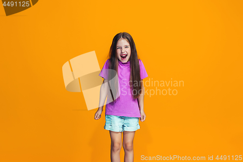 Image of The happy teen girl standing and smiling against orange background.