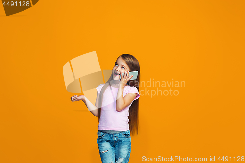 Image of The happy teen girl standing and smiling with phone