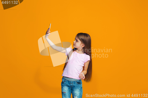 Image of The happy teen girl standing and smiling with phone