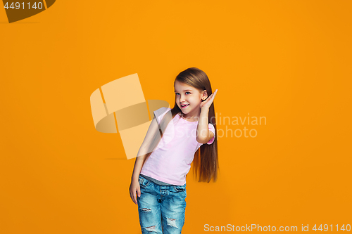 Image of The young teen girl whispering a secret behind her hand