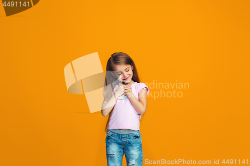 Image of The happy teen girl standing and smiling with phone