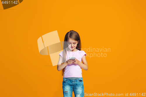 Image of The happy teen girl standing and smiling with phone