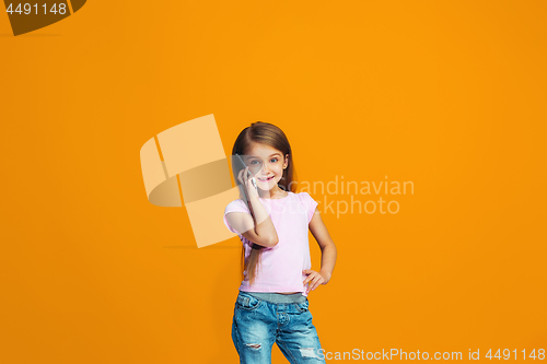 Image of The happy teen girl standing and smiling with phone