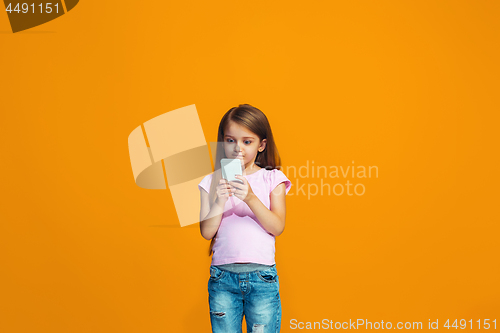 Image of The happy teen girl standing and smiling with phone