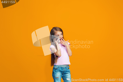 Image of The happy teen girl standing and smiling with phone