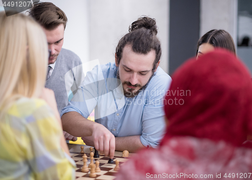 Image of multiethnic group of business people playing chess