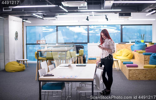 Image of redhead businesswoman using mobile phone at office