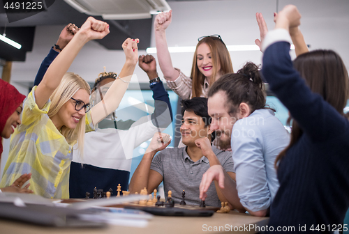 Image of multiethnic group of business people playing chess