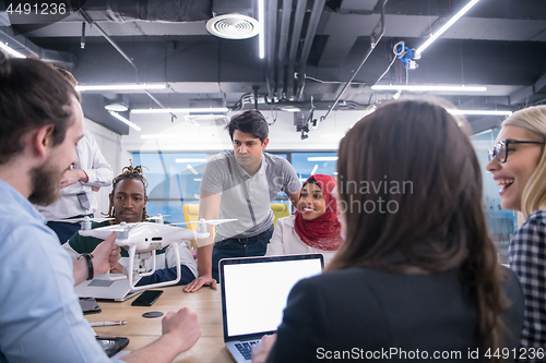 Image of multiethnic business team learning about drone technology