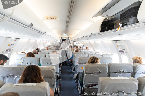 Image of Interior of commercial airplane with passengers on their seats during flight.