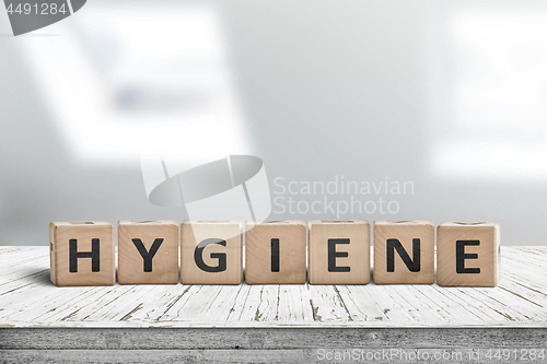 Image of Hygiene sign on a wooden table in a bright bathroom