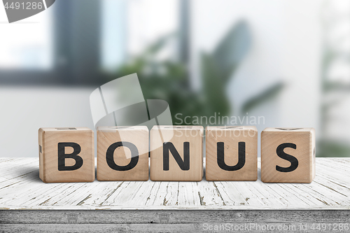 Image of Bonus reward sign on a white table in a bright office 