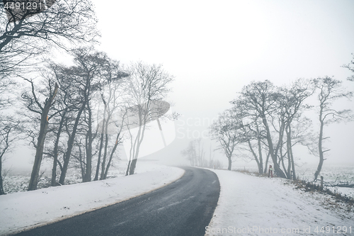 Image of Highway curvy road in a misty winter scenery