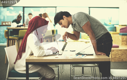 Image of black muslim business woman having a meeting with her indian mal