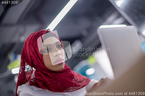 Image of black muslim business woman ,working on laptop computer