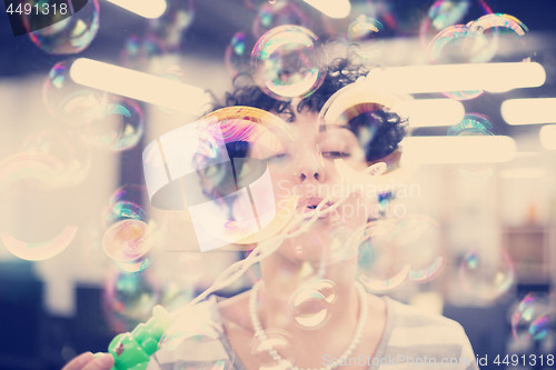 Image of software developer having fun while making soap bubble