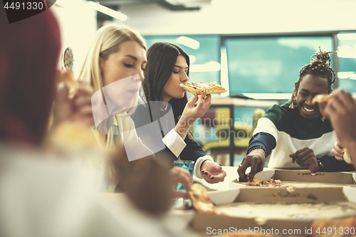 Image of multiethnic business team eating pizza