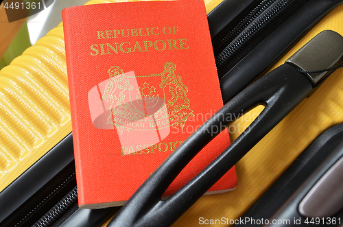 Image of Singapore passport on a yellow suitcase