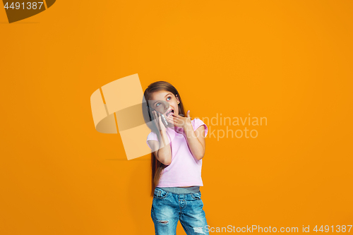 Image of The happy teen girl standing and smiling with phone