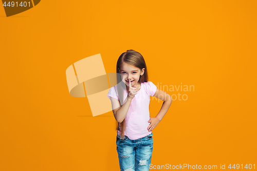 Image of The young teen girl whispering a secret behind her hand