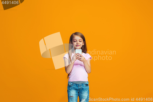 Image of The happy teen girl standing and smiling with phone