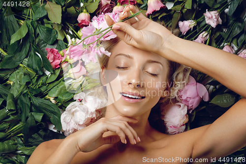 Image of Beautiful girl lying in flowers