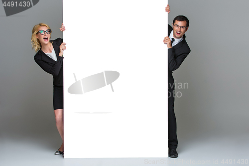 Image of Businessman and business woman with big empty poster