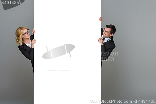 Image of Businessman and business woman with big empty poster