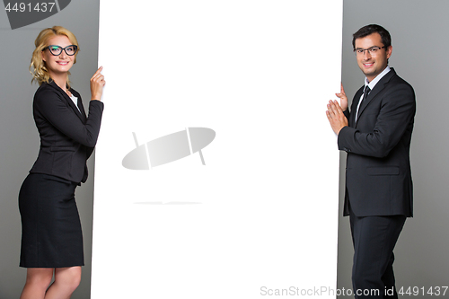 Image of Businessman and business woman with big empty poster