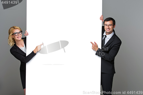 Image of Businessman and business woman with big empty poster