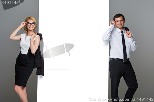 Image of Businessman and business woman with big empty poster