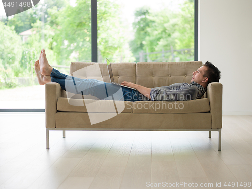 Image of Man using laptop in living room