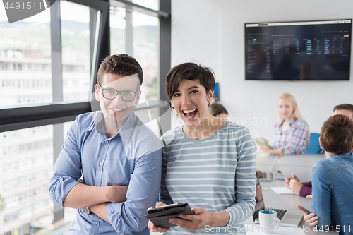 Image of Two Business People Working With Tablet in office