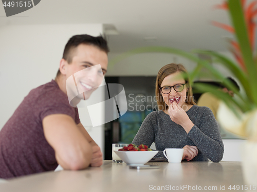Image of couple enjoying morning coffee and strawberries