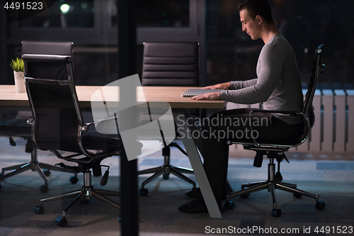 Image of man working on laptop in dark office