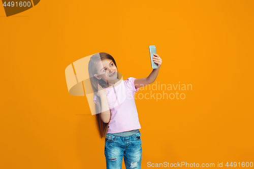 Image of The happy teen girl standing and smiling with phone