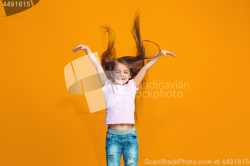 Image of The happy teen girl standing and smiling against orange background.