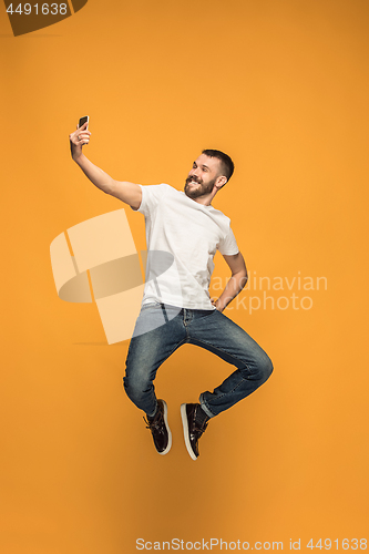 Image of Time to take selfie. Full length of handsome young man taking selfie while jumping