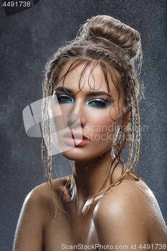 Image of Beautiful girl with blue makeup in water drops