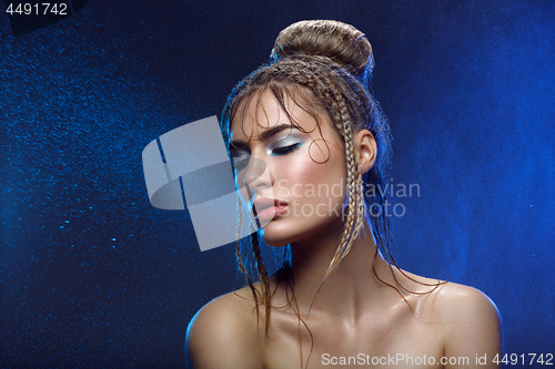 Image of Beautiful girl with blue makeup in water drops