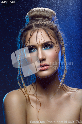 Image of Beautiful girl with blue makeup in water drops