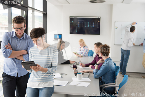 Image of Two Business People Working With Tablet in office