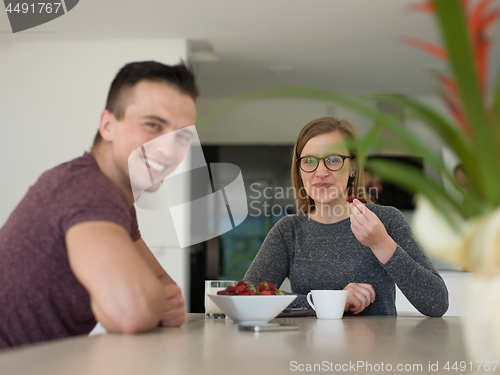 Image of couple enjoying morning coffee and strawberries