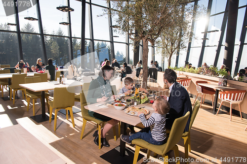 Image of Young parents enjoying lunch time with their children