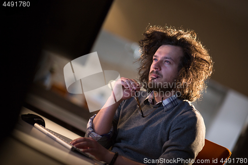 Image of man working on computer in dark office